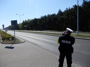 policjant ruchu drogowego podczas wykonywania pomiaru prędkości