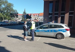 Policjant ruchu drogowego podczas rozmowy z pieszym jako jednym z uczestników ruchu drogowego