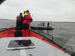 Policjanci na  łodziach podczas poszukiwań opisanych w treści informacji